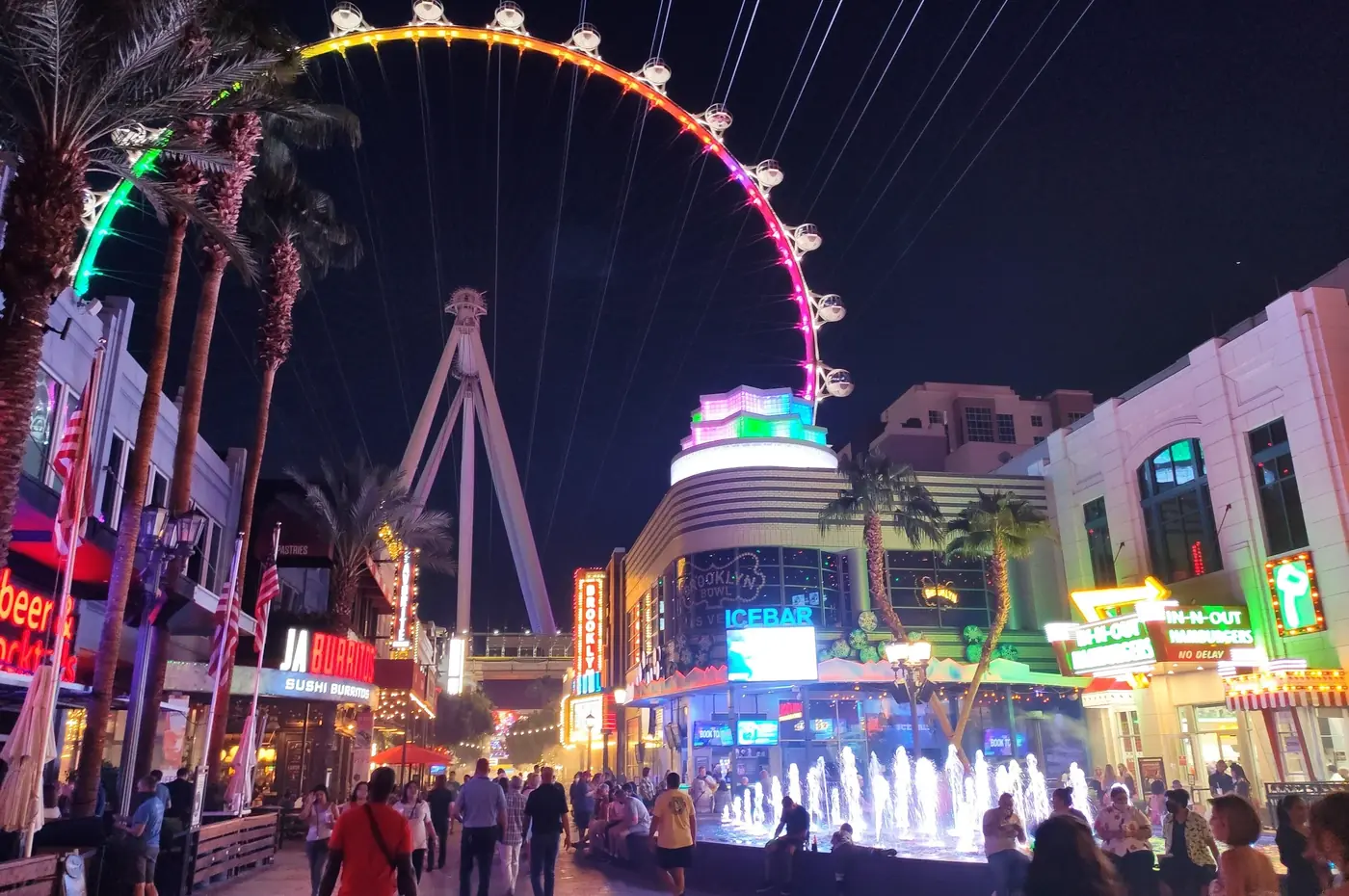 High Roller illuminated above The LINQ Promenade at night